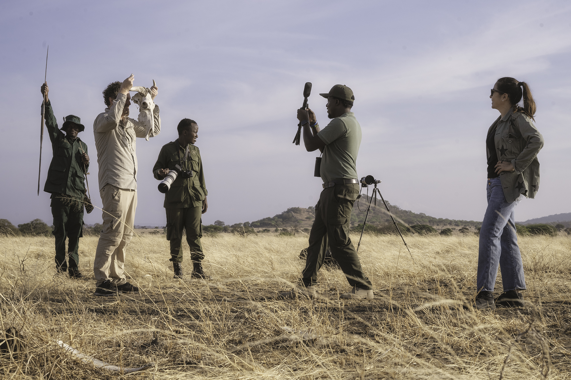 A guide shows the group a skull found on a walking safari